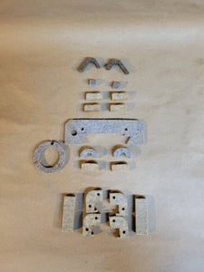 A set of various shaped felt wipers for a Monarch lathe, displayed on a beige background. 